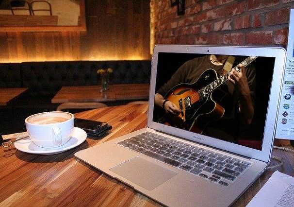 computer screen with teacher helping to learn to play guitar YouTube style