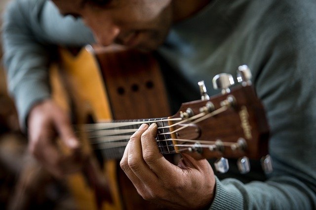 Man playing the notes on the A string guitar