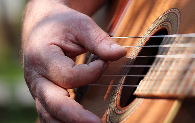 Man hand playing alternating bass notes on guitar